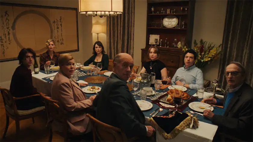People sit at a table and look at a camera for a photo in the movie Bad Shabbos, one of the 15 films to watch at the Tribeca Film Festival according to Loud and Clear Reviews
